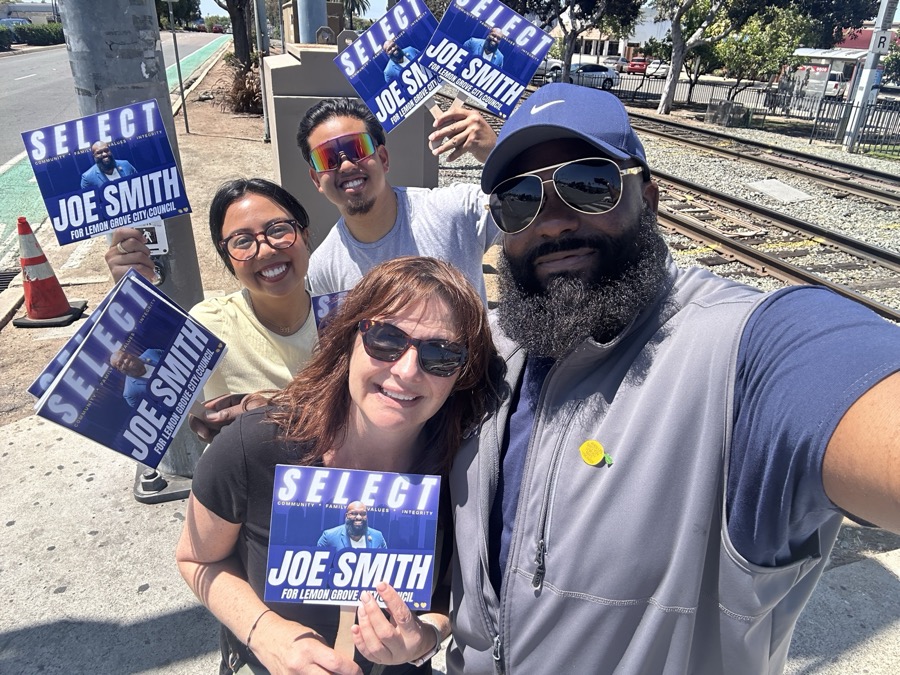 Joe Smith taking a selfie with supporters holding Select Joe Smith signs