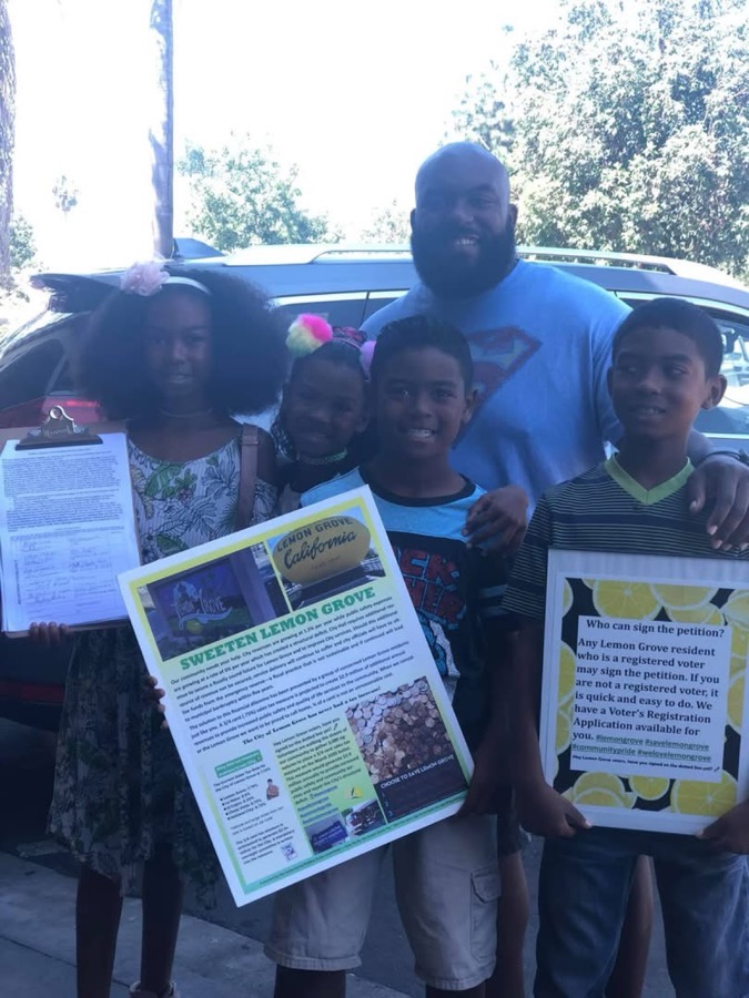 Joe Smith with kids holding Sweeten Lemon Grove petition flyers